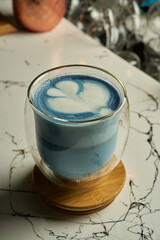 Blue latte on wooden coaster