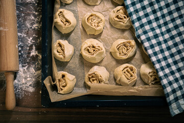 Cinnamon rolls covered with cloth before baking. Proofing stage in pastry making.