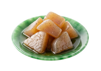 A pile of light beige, triangular konjac slices sits on a glossy, marbled, jade-green plate.