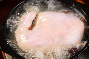 Fototapeta premium Raw Whole Chicken Breasts Boiling in Water with Spices - Fresh Farm Poultry Cooking