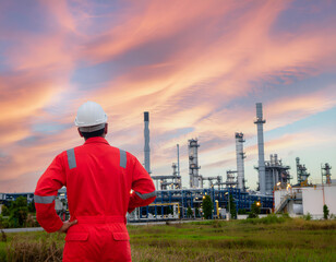 refinery worker, industrial landscape, oil refinery, sunset sky, clouds, red overalls, hard hat,...