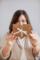 Woman Showing Bronze Certificate Envelope. Stylish Gift Certificate Presented by Woman