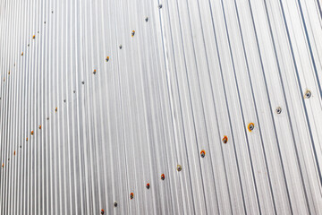 Corrugated metal wall with visible fasteners in diagonal pattern