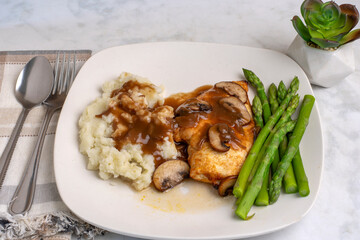 chicken breast top with gravy and mushrooms