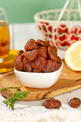 Dried Lychee Fruits in Bowl on Wooden Board with Tea and Lemon Slice