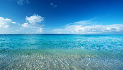 Fototapeta premium Tranquil Clear Ocean Water With Gentle Waves Under Bright Blue Sky And Soft White Clouds On A Sunny Day By The Coastline