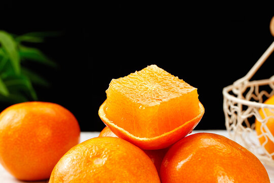 Fresh Orange Citrus Fruits Cut Open Showing Juicy Flesh and Textured Peel with Wicker Basket