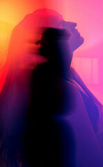 moody experimental portrait of a brunette woman with orange-pink-red glow in cyberpank style