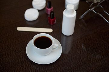 Cup of Coffee on a Wooden Table with Beauty Items Nearby