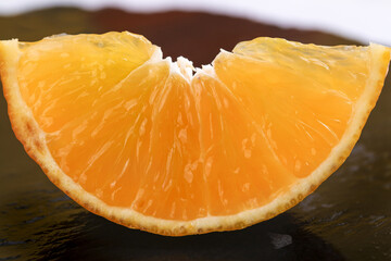 Fresh Orange Slice with Juicy Segments on Dark Wood Surface - Healthy Citrus Fruit Close-up
