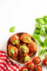 Meatballs in tomato sauce on white background.