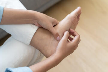 Close-up bare feet of person feeling itchy and irritated try to scratching by toe.