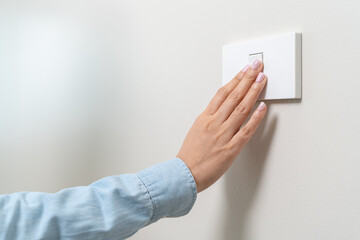 Save energy concept, Close-up person turn off switch off light on the wall © Pormezz