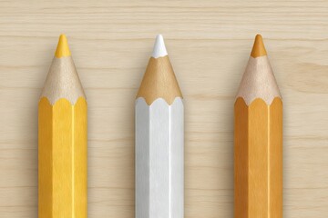 Three sharpened colored pencils yellow and white on a wooden background.