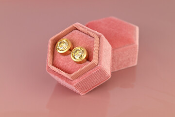 A earrings is in a pink velvet box