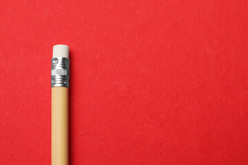 One graphite pencil on red background, top view. Space for text