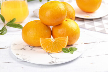 Fresh Oranges on Marble Plate with Mint Garnish - Healthy Citrus Fruit Display on White Wood Background