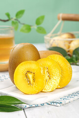 Fresh Yellow Kiwifruit from New Zealand Sliced on White Plate with Natural Kitchen Setting