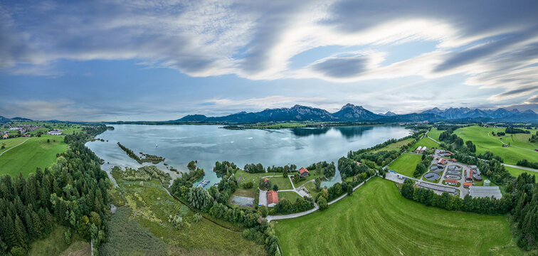 aerial photo of the alpine landscape at lake Forgensee in the eastern Allgaeu near city of Fuessen with Neuschwanstein castle in backround, Bavaria, Germany