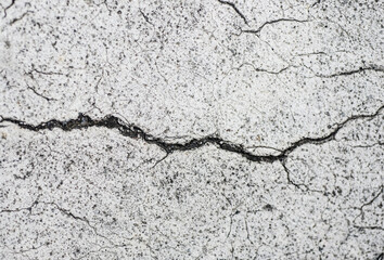 Obraz premium Cracks on the cement floor, close-up. Abstract background.