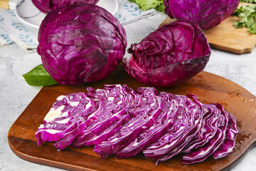 Obraz premium Fresh Purple Red Cabbage Sliced on Wooden Board with Kale Leaves - Healthy Organic Vegetables