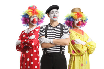 Two clowns and a mime posing with crossed arms