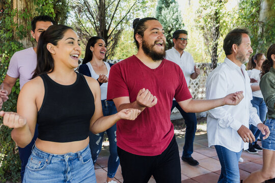 Group of latino friends enjoying a salsa dancing class outdoors in Mexico Latin America. Hispanic people moving to the rhythm and having a fun together