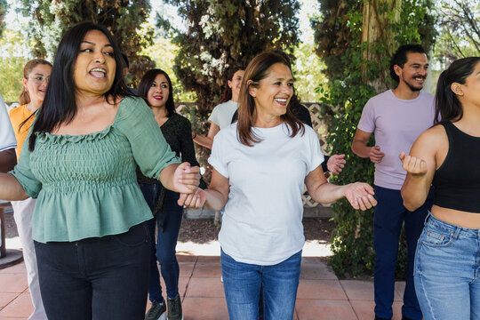 Group of latino friends enjoying a salsa dancing class outdoors in Mexico Latin America. Hispanic people moving to the rhythm and having a fun together
