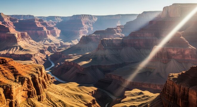 Breathtaking panoramic view of Grand Canyon's sculpted cliffs and flowing river, illuminated by golden light and clear sky - Powered by Adobe