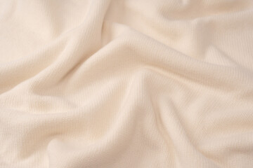 Soft milky color merino wool sweater texture as a background.
