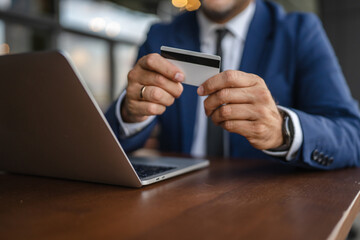 Businessman making online payment using credit card and laptop