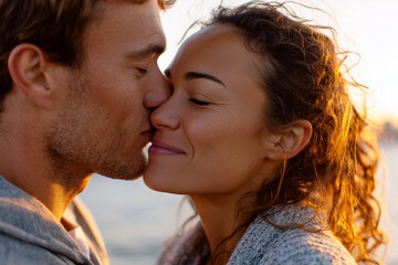 Fototapeta premium Couple kissing in the warm light of sunset