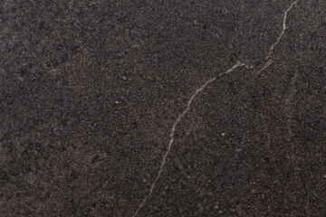 Dark textured stone surface with subtle lines and a smooth finish, perfect for home renovation projects and modern designs