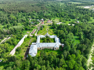 A panoramic aerial shot of the Andreevskoe sanatorium complex and other historical buildings, nestled in a clearing within a vast green forest.