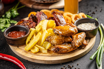 Chicken wings with fries, sausages, onion rings and sauces