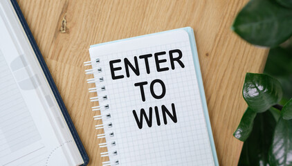 Enter to Win text on open notebook on wooden background, Business Concept