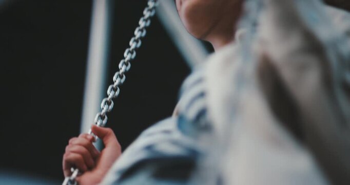 Beautiful young relaxed girl swinging on a swing low angle shot