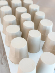 Slip casted coffee and espresso cups with various patterns drying for bisque fire process