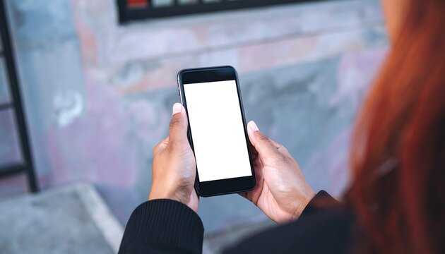 Close-up rear view of a woman using a smartphone for Cyber Monday home shopping against a neutral background, conveying a focused mood.