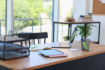 Home workspace. Modern laptop and stationery on wooden desk indoors
