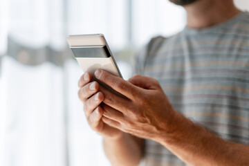 Man using smartphone, browsing internet, checking social media, sending text message
