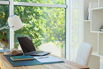 Home workplace. Laptop, headphones, coffee and stationery on wooden table, space for text