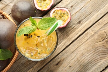 Tasty passion fruit drink with mint and fresh fruits on wooden table, flat lay. Space for text