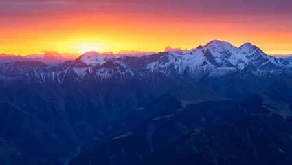Majestic mountain range at sunrise with snow capped peaks and vibrant sky