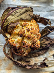 A roasted head of cauliflower with charred leaves