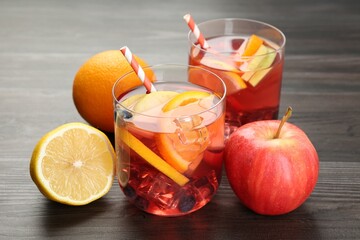 Tasty punch in glasses and fresh fruits on wooden table, closeup. Refreshing drink