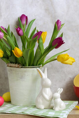 Easter decoration with colorful tulips and ceramic rabbits