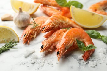 Tasty grilled shrimps and products on white marble table, closeup. Delicious seafood dish