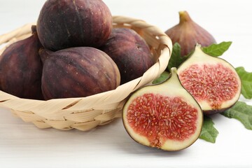 Whole and cut figs on white table, closeup