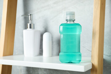 Bottle of mouthwash, soap and deodorant on shelf in bathroom, selective focus